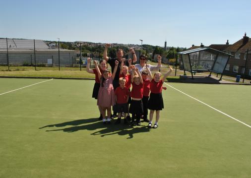 ResizedImageWzUwNiwzNTld Members of Anagh Schools Healthy School Commitee on the new AstroTurf with Chairman of Manx Lottery Trust Sarah Kelly and Headteacher Rob Coole